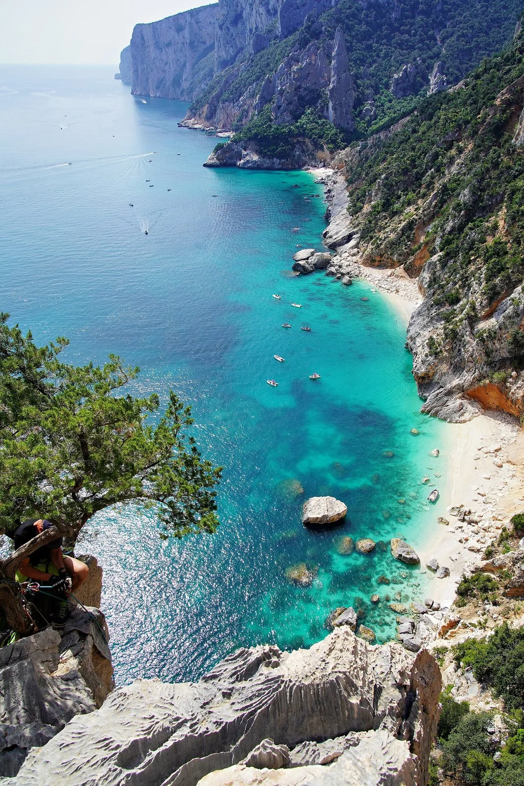 Una cala di acqua turchese vista dall'alto della falesia sulla costa di Baunei
